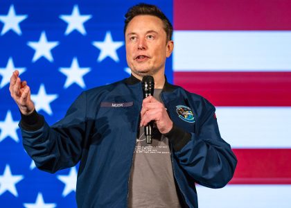 Elon Musk speaking at a public event or appearing before cameras.