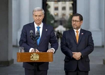 The flags of Chile and Venezuela displayed side by side at a diplomatic venue.