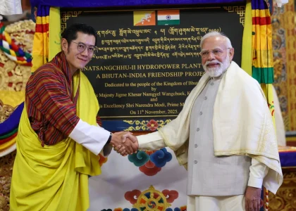 Indian and Bhutanese officials exchanging development cooperation documents in Thimphu.