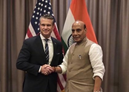 Indian and United States defence ministers meeting beside their national flags in Cebu.