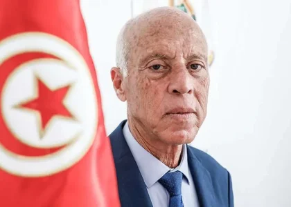 Demonstrators march through Tunis carrying national flags during a large protest.
